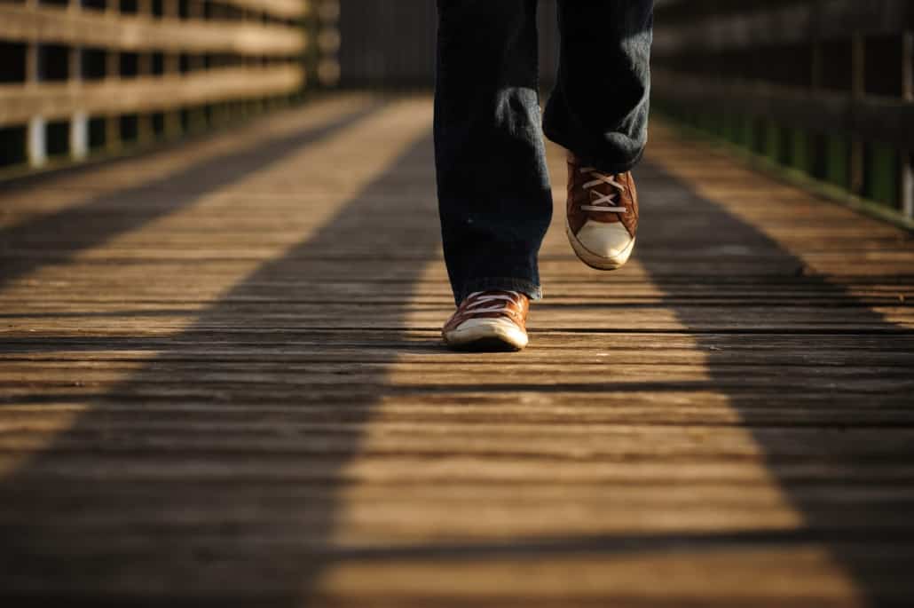 person walking on a small wooden bridge